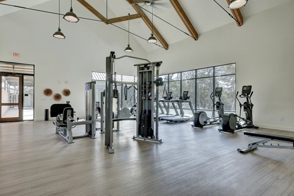 Fully-equipped fitness center at Arbolada Apartments with modern workout machines and free weights