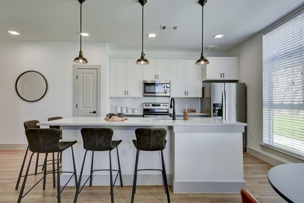 Modern kitchen with stainless steel appliances at Arbolada Apartments