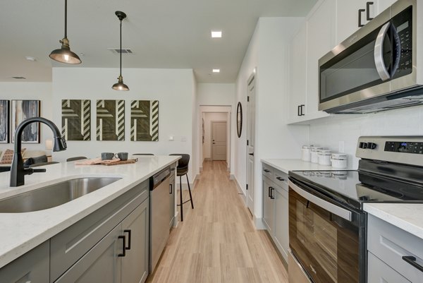 Modern kitchen with stainless steel appliances at Arbolada Apartments
