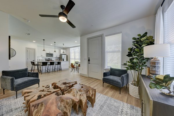 Spacious living room with modern decor in Arbolada Apartments, showcasing luxury apartment living