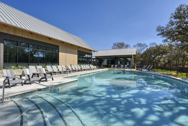 Tranquil outdoor pool at Arbolada Apartments surrounded by lush greenery, ideal for relaxation and leisure activities