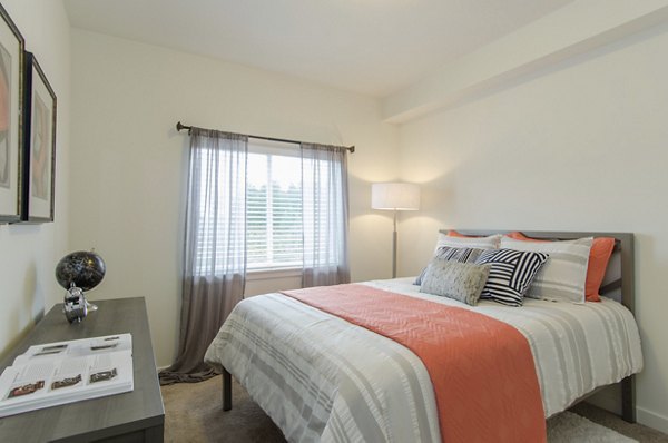 Cozy bedroom with modern furnishings at Britton Place Apartments, offering comfort and style in a luxury living environment