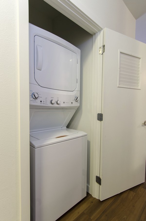 Modern laundry room with high-efficiency washers and dryers at Britton Place Apartments