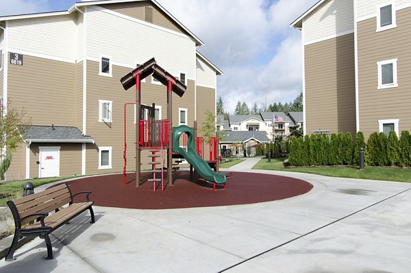 Colorful playground at Britton Place Apartments featuring slides, swings, and climbing structures for family-friendly outdoor fun