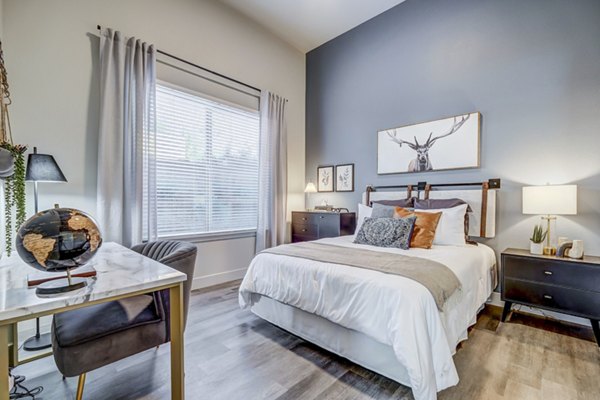 Cozy bedroom with elegant decor at The Plaza at Pikes Peak Apartments featuring mountain views