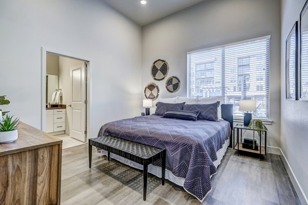Cozy bedroom with modern decor at The Plaza at Pikes Peak Apartments, showcasing luxury living spaces