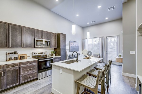 Kitchens with modern stainless steel appliances at The Plaza at Pikes Peak Apartments