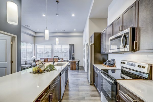 Modern kitchen with stainless steel appliances at The Plaza at Pikes Peak Apartments