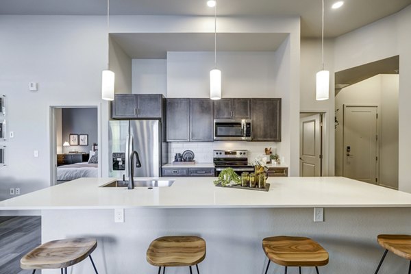 Modern kitchen with stainless steel appliances at The Plaza at Pikes Peak Apartments