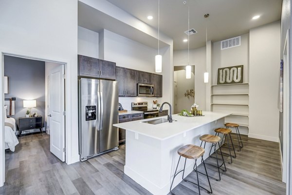 Modern kitchen with stainless steel appliances at The Plaza at Pikes Peak Apartments