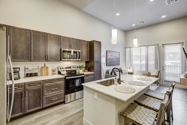 Modern kitchen with stainless steel appliances at The Plaza at Pikes Peak luxury apartments