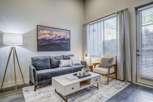 Spacious living room with modern decor in The Plaza at Pikes Peak Apartments