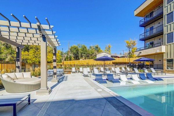 Resort-style pool with lounge chairs at The Plaza at Pikes Peak Apartments