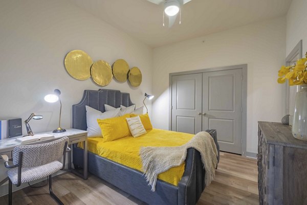 Modern bedroom with sleek furnishings and natural light at Seville Uptown Apartments