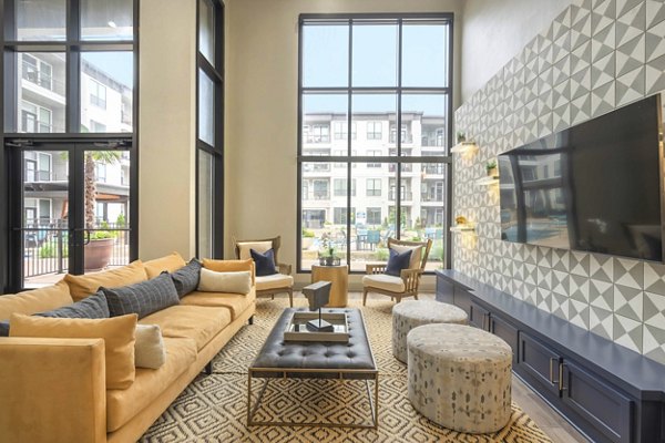 Modern clubhouse with cozy seating and large TV at Seville Uptown Apartments in a vibrant, upscale neighborhood