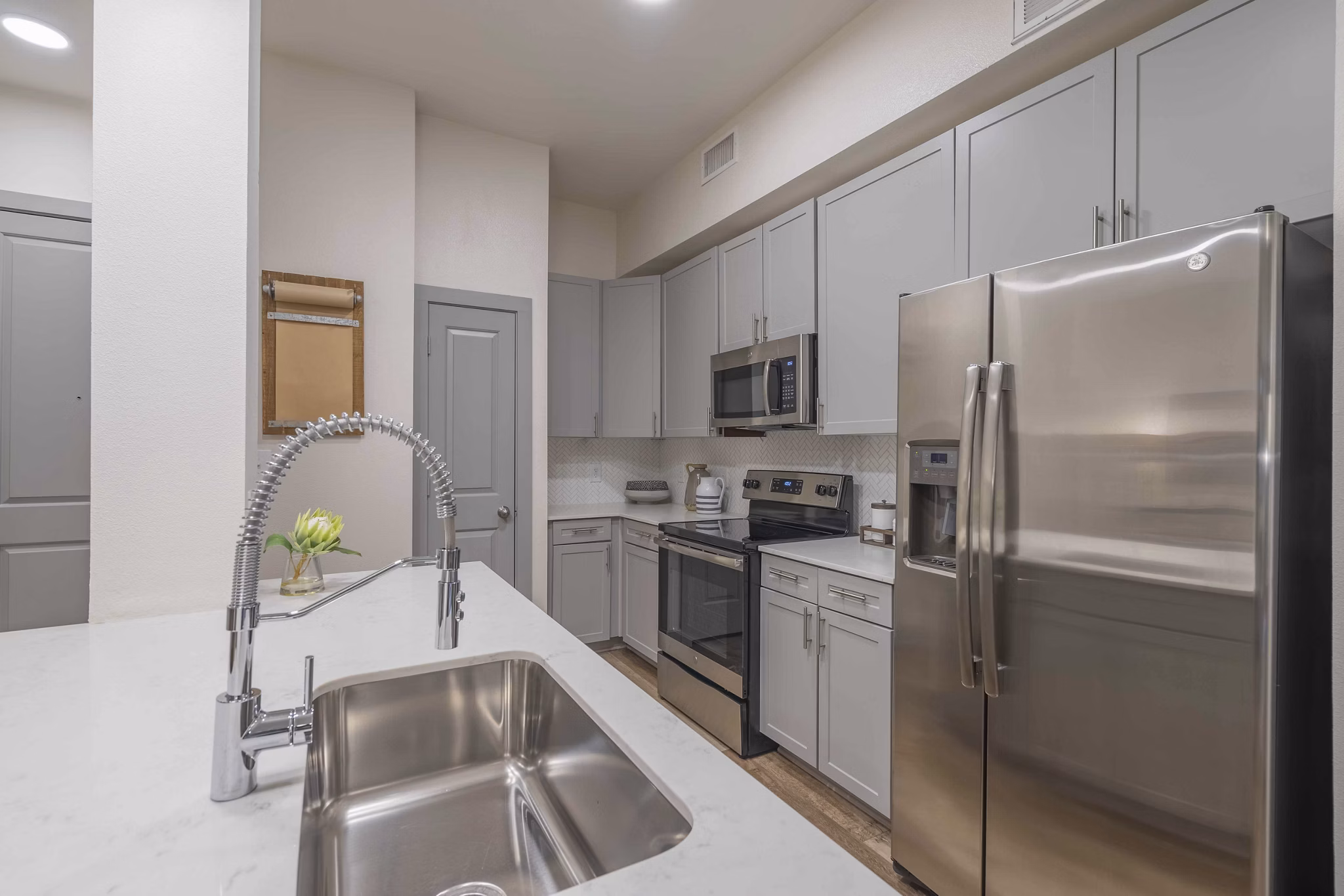 Modern kitchen with stainless steel appliances in Seville Uptown Apartments