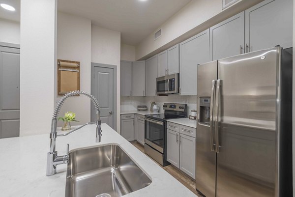 Modern kitchen with stainless steel appliances in Seville Uptown Apartments