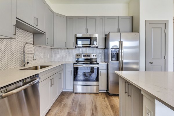 Modern kitchen featuring stainless steel appliances at Seville Uptown Apartments