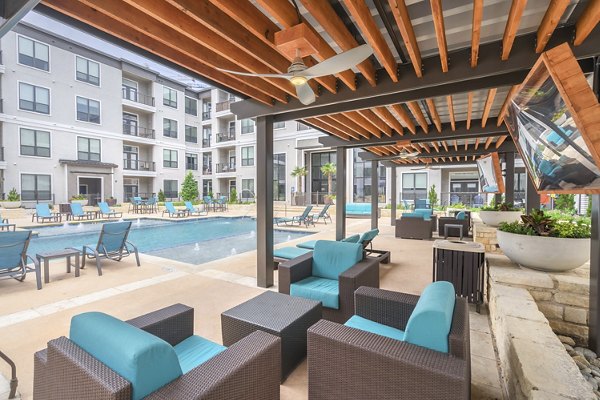Relaxing pool area with loungers at Seville Uptown Apartments, perfect for unwinding in a luxurious setting