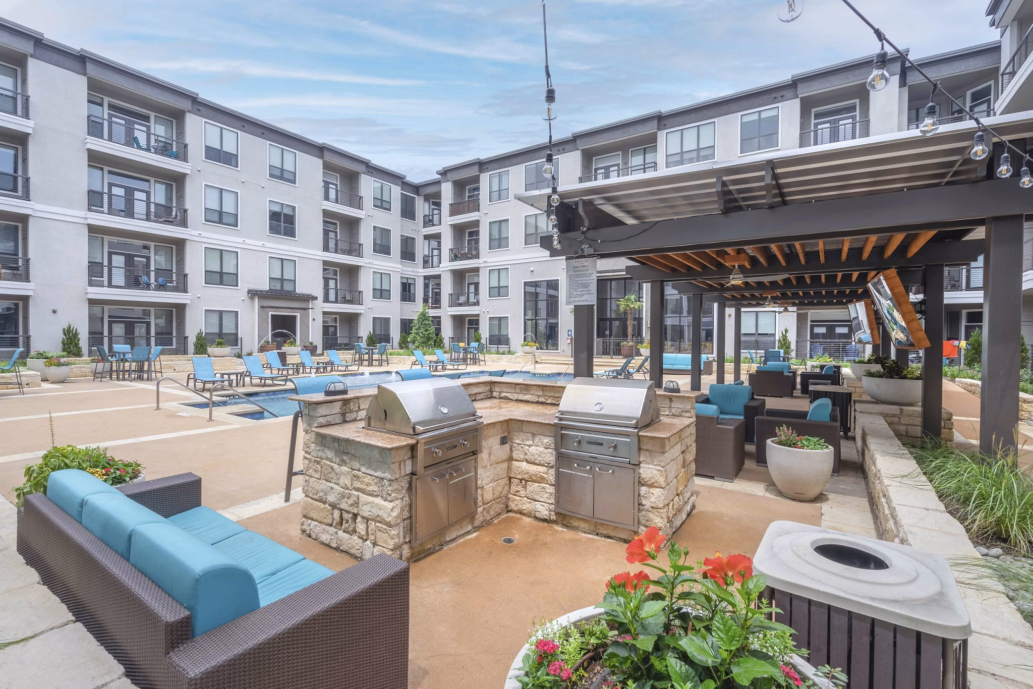 Outdoor grill area with modern seating at Seville Uptown Apartments