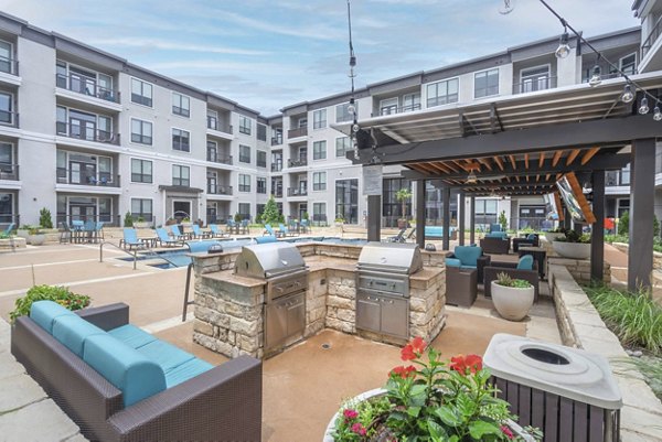 Outdoor grill area with modern seating at Seville Uptown Apartments