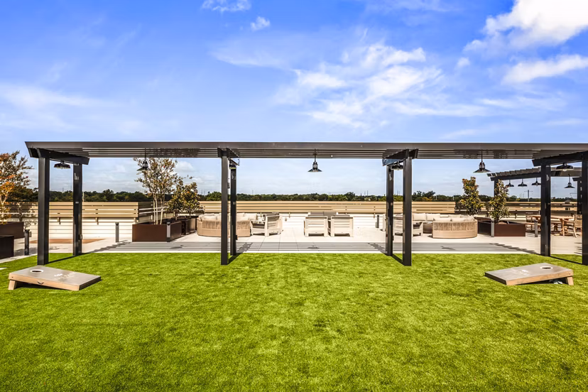 Outdoor recreational area with lush greenery at The Park at Woodbridge Station Apartments, ideal for relaxation and leisure activities