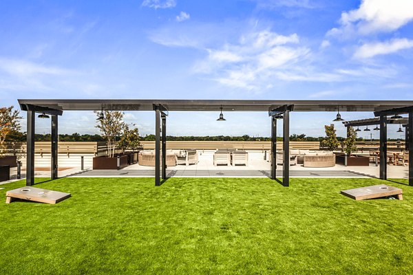 Outdoor recreational area with lush greenery at The Park at Woodbridge Station Apartments, ideal for relaxation and leisure activities