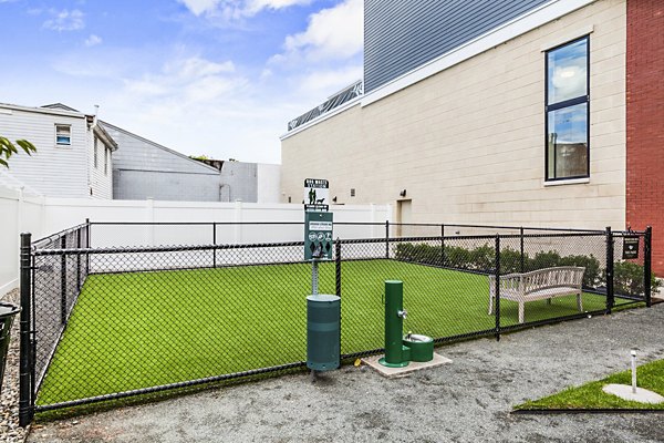 Fenced dog park with agility equipment at The Park at Woodbridge Station Apartments