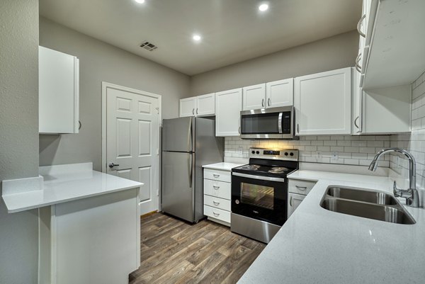 Modern kitchen with stainless steel appliances and marble countertops in Mountainside Apartments, a luxury property by Greystar