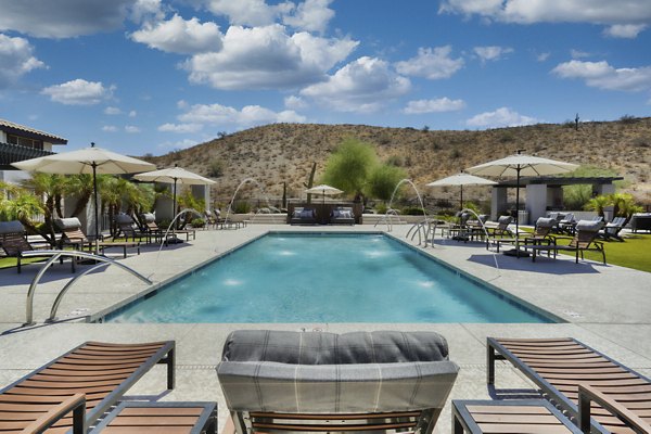 Sparkling outdoor pool at Mountainside Apartments with seating and scenic views