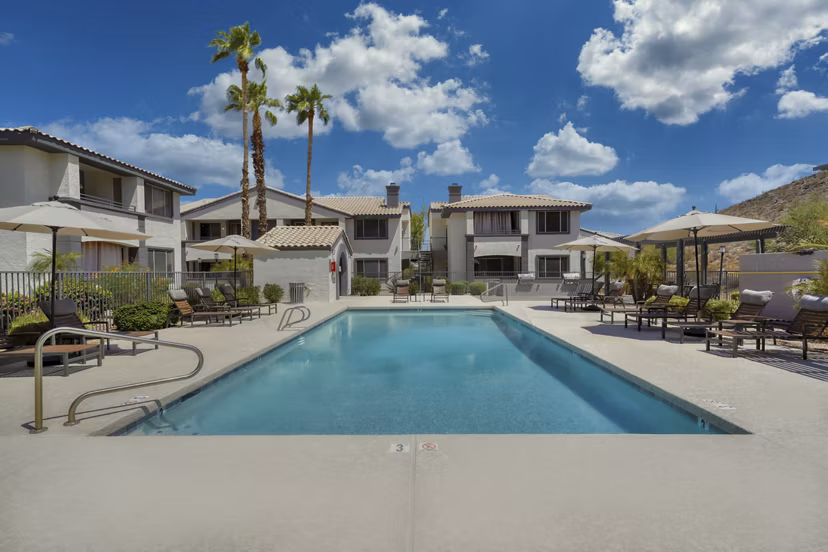Relax by the outdoor pool with mountain views at Mountainside Apartments