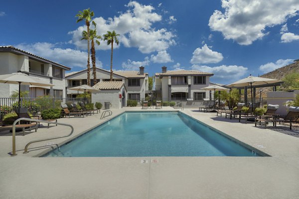 Relax by the outdoor pool with mountain views at Mountainside Apartments