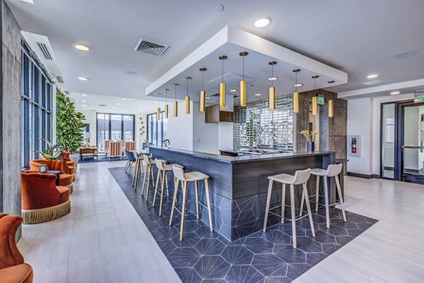 Modern clubhouse with plush seating and large TV at The Charles Apartments