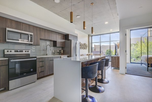 Modern kitchen with stainless steel appliances at The Charles Apartments