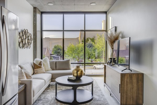 Spacious living room with modern furnishings at The Charles Apartments