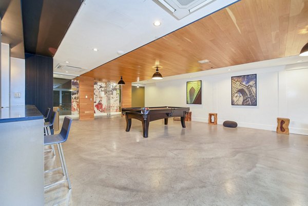 Clubhouse game room featuring pool table and lounge seating at 1209 Dekalb Apartments, offering modern luxury amenities