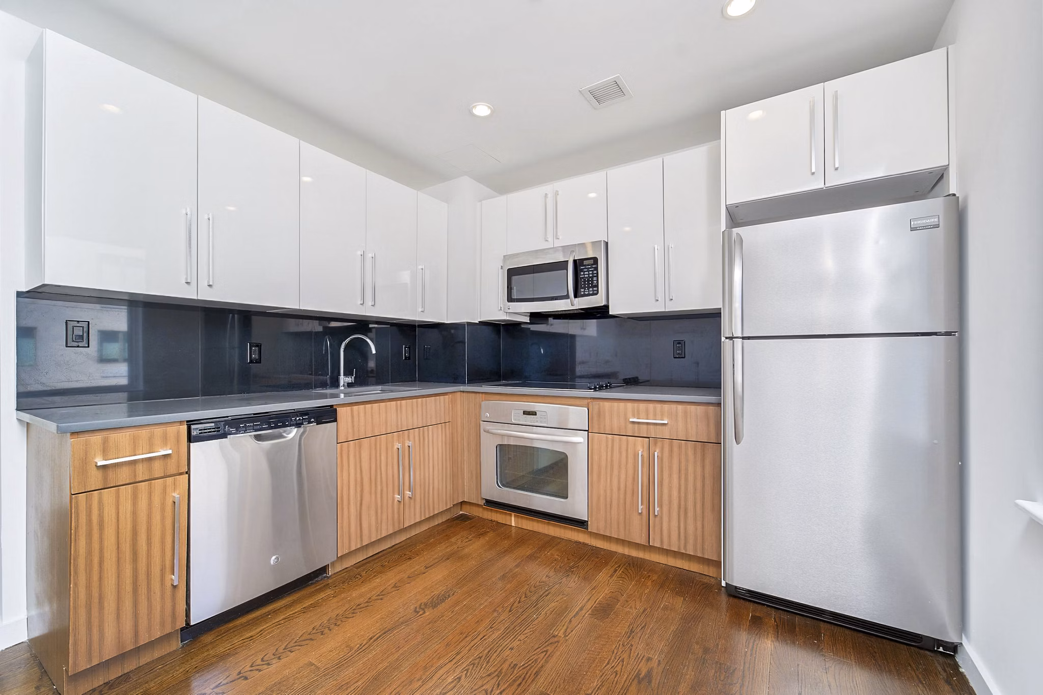 Modern kitchen with sleek countertops and stainless-steel appliances in 1209 Dekalb Apartments