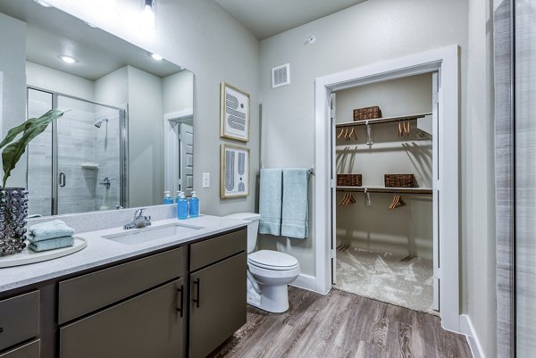 Bathroom featuring sleek fixtures and marble countertops at Moderno Apartments