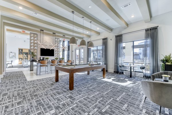 Game room with pool table and arcade games at Moderno Apartments, offering entertainment spaces for residents