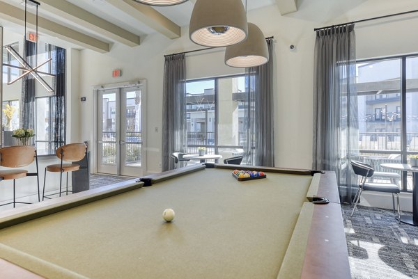 Game room with billiards and cozy seating at Moderno Apartments, perfect for leisure and entertainment