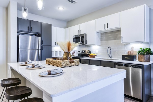 Kitchen with stainless steel appliances and granite countertops in Moderno Apartments