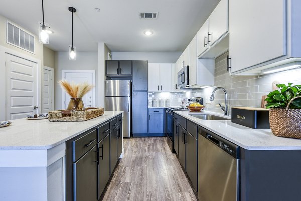Contemporary kitchen with sleek cabinetry and stainless steel appliances at Moderno Apartments