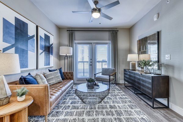 Living room featuring modern decor and large windows at Moderno Apartments