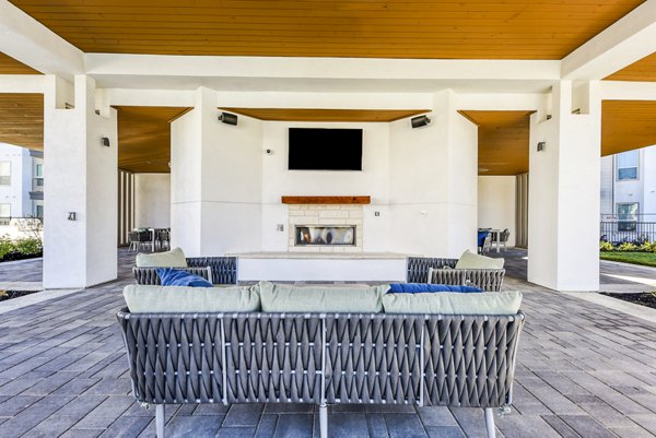 Cozy outdoor patio with fire pit at Moderno Apartments, perfect for relaxation and social gatherings