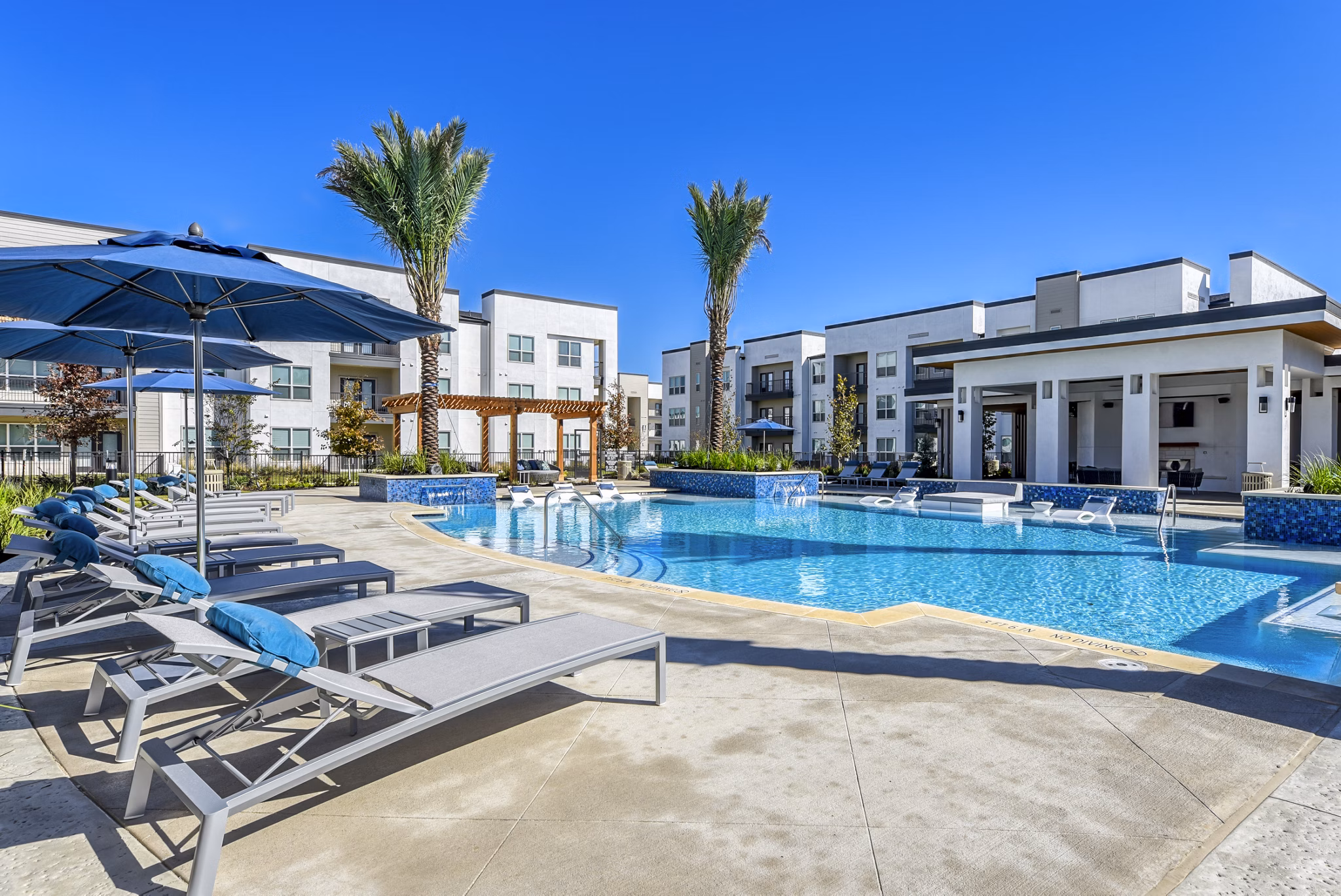 Luxurious pool area at Moderno Apartments featuring sleek design and comfortable lounge chairs for relaxation
