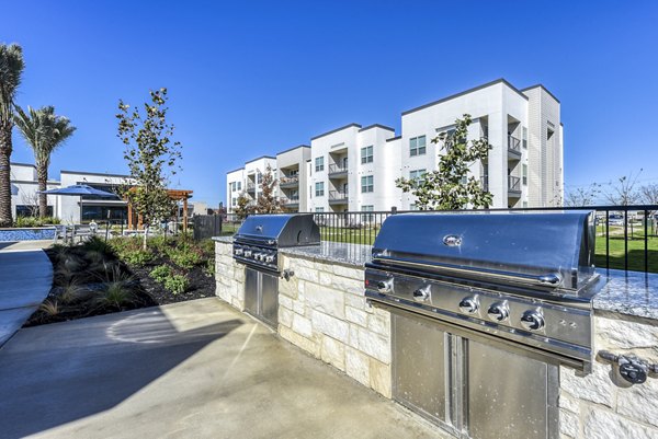 Outdoor grill area featuring stainless steel BBQs at Moderno Apartments, ideal for social gatherings and relaxing in a luxury setting