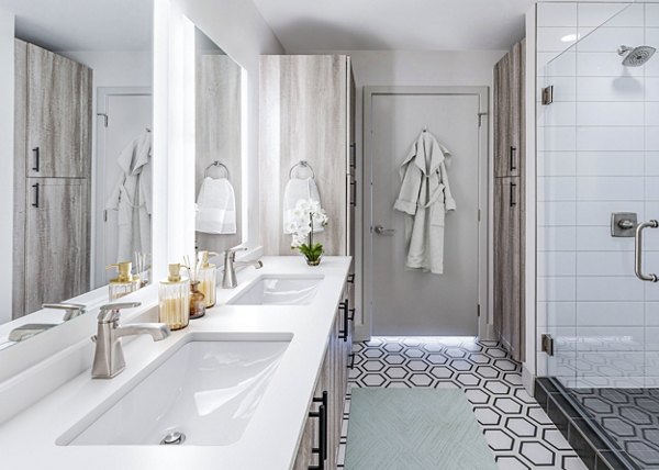 Bathroom featuring modern fixtures and marble countertops at Fallyn Apartments