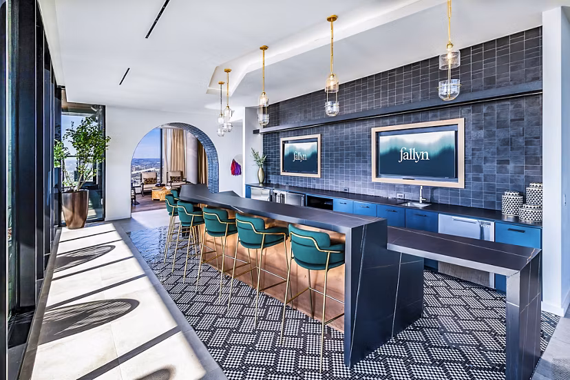 Clubhouse kitchen featuring modern appliances and island seating at Fallyn Apartments