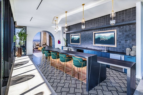 Clubhouse kitchen featuring modern appliances and island seating at Fallyn Apartments