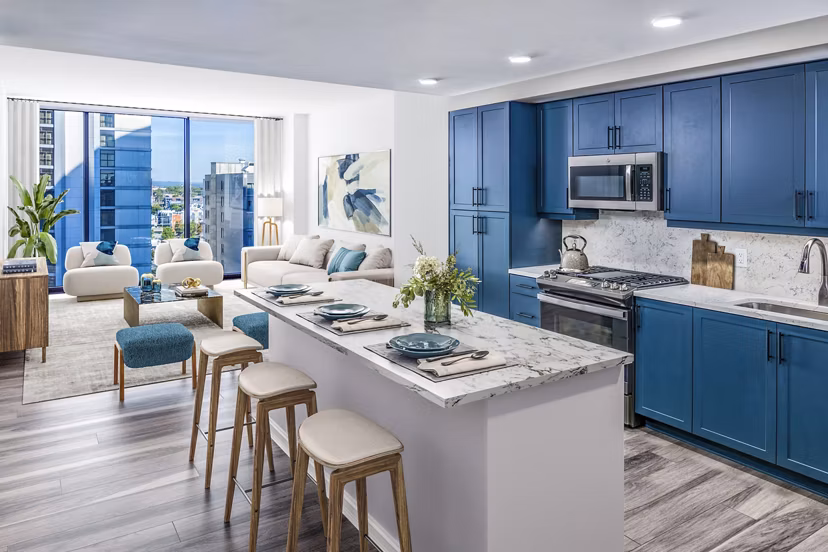Modern kitchen with stainless steel appliances and quartz countertops in Fallyn Apartments